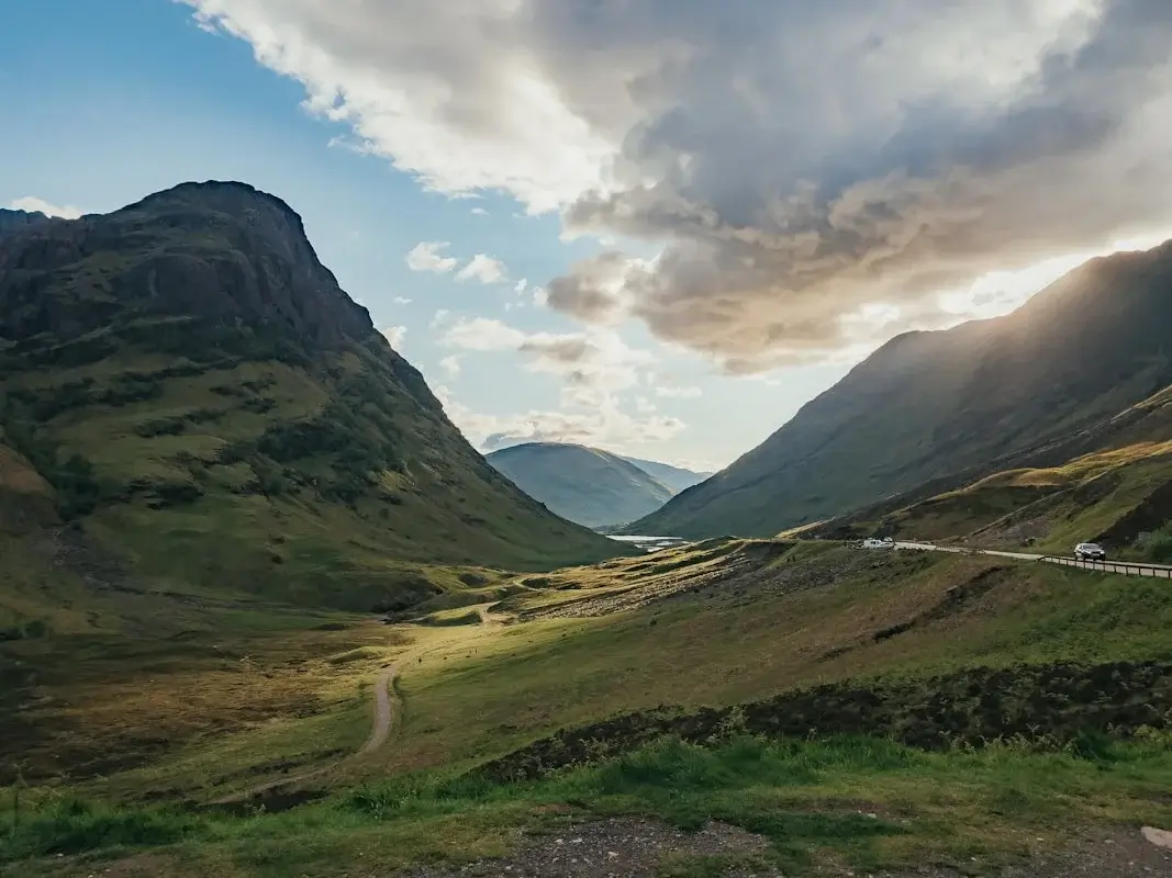 Sweeping view of a Scottish glen with mountains, loch and clouds